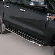 A close-up side view of a black pickup truck showing a long chrome side step running along the lower door, with part of the rear wheel and front wheel visible against a plain light gray studio background.